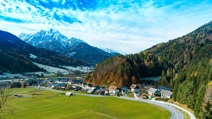 Panoramic view on the road with  mountain village environs, grassy hills. Picturesque traveling, seasonal at countryside 