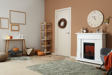 Interior of modern living room with fireplace and autumn decorations