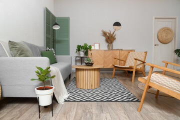 Interior of modern living room with grey sofa, armchairs and coffee table