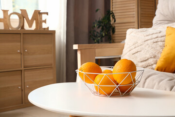 Basket with oranges on coffee table in living room, closeup
