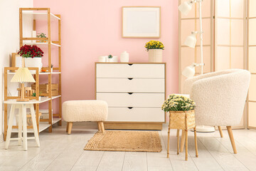 Interior of stylish living room with white sofa and beautiful chrysanthemum flowers