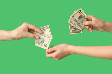 Female hands with money on green background