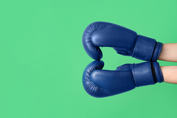Female hands in boxing gloves on green background