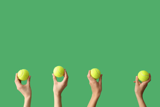 Female hands with tennis balls on green background