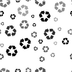 Seamless vector pattern with recycling symbols, creating a creative monochrome background with rotated elements. Vector illustration on white background