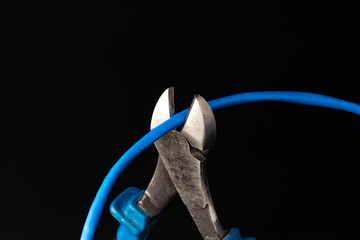 Cutting pliers cut electric cable close up