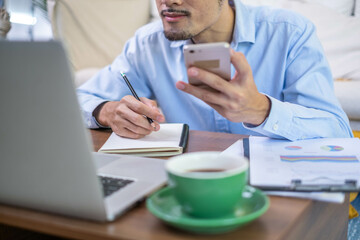 Obraz premium Closeup professional businessman hand pen writing work document strategy on tablet technology indoor workplace office table, adult entrepreneur business man manager person note finance report notepad