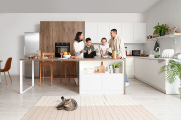 Happy family with cat cooking in kitchen