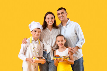 Happy family with lunchboxes on yellow background