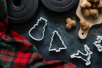 Christmas cookie cutters, gym dumbbells, gingerbread cookies and tartan plaid. Healthy fitness...