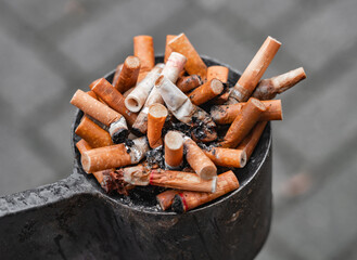 Zigaarettenkippen in einem vollen Aschenbecher