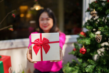 Obraz na płótnie Canvas Happy excited asian woman hands holding Christmas gift box. cheerful girl packing Xmas present or open box xmas new year birthday gift.