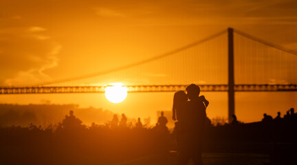 Sunset Silhouette: Two People have hag and kiss in Front of a big Bridge