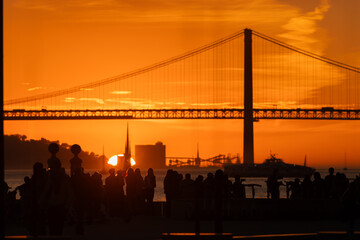 Sunset Reflections: A Gathering of People Admiring a Majestic Bridge