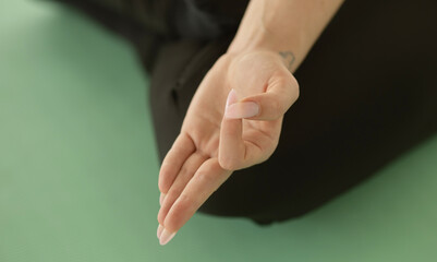 Close up of hands young woman working out on fitness mat, doing lotus yoga pose at the gym. Yoga...