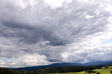 Fototapeta na wymiar Cloudy stormy sky over hilly terrain