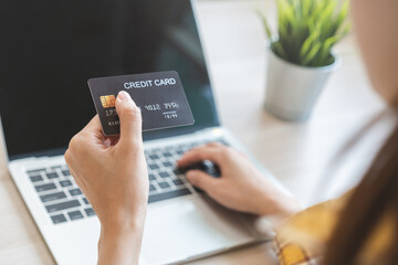 Internet banking, Online shopping at home, asian young woman hand in typing on keyboard, holding credit card, using laptop computer, spending money with purchase on store at home. Shopaholic ecommerce