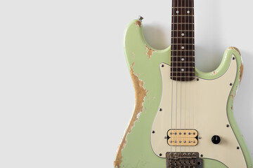 Old green electric guitar on white background. Grunge wallpaper