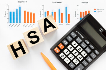 HSA symbol. HSA - Health Savings Accoun. text on three blocks on the table