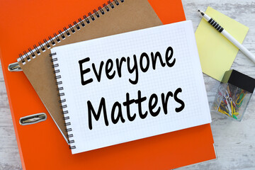 Everyone Matters desktop orange folder. text on a notebook