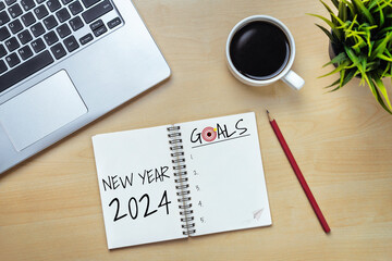 2024 Happy New Year Resolution Goal List and Plans Setting - Business office desk with notebook written about plan listing of new year goals and resolutions setting. Change and bliss concept.