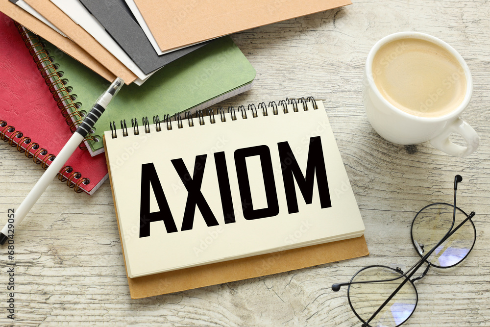 Poster axiom different notepads and cards on the table. a cup of coffee. text on a notebook