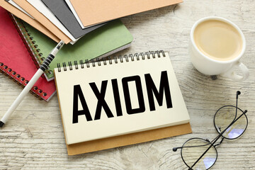 Axiom different notepads and cards on the table. a cup of coffee. text on a notebook