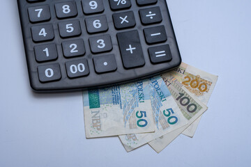 Kalkulator elektroniczny postawiony na polskich papierowych banknotach