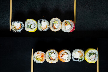 sushi with chopsticks on the dark background
