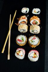 sushi with chopsticks on the dark background