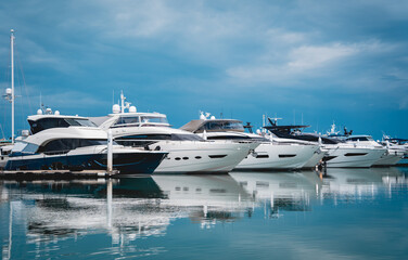 Fototapeta premium Many white modern yachts moored at the pier of marina.
