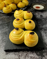 Lussekatter, Swedish S-shaped saffron buns for St Lucia, with a dark background.