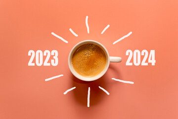 Happy new year and Merry Christmas 2024. Cup of coffee change and download 2023 to 2024 on orange background. Start up and New Year Concept. Copy space - obrazy, fototapety, plakaty