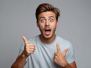 young surprised man standing and pointing to top with blank space