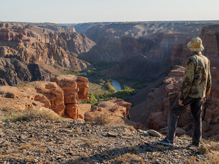Tourist on the edge of a cliff overlooking the Charyn Canyon, Almaty region, Kazakhstan