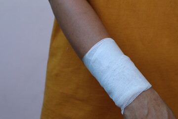 The woman wore a yellow shirt and had a bandage wrapped around her hand. After being injured while cooking
