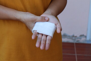 The woman wore a yellow shirt and had a bandage wrapped around her hand. After being injured while cooking