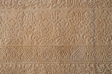 White stone relief with arabesques on wall in madrasa Ben Youssef Madrasa in Marrakesh, Morocco