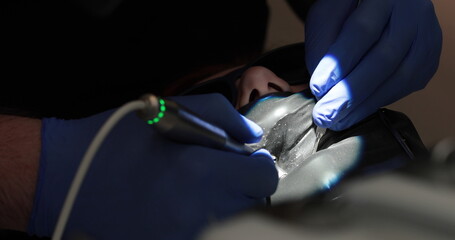 Doctor's hands with a working tool. Preparation and process of dental treatment. Dental instrument...
