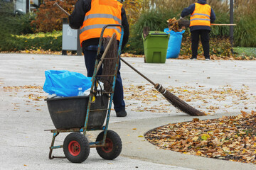 Workers collecting autumn leaves in the town square