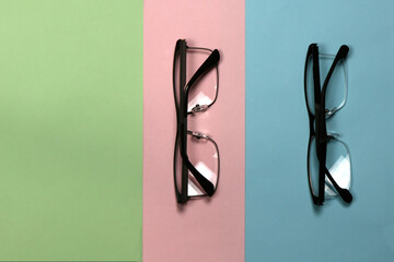 Pair of reading glasses isolated on three colored background. Fashion spectacles for man and woman
