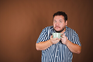 Early morning and various news. Funny fat man with a mug of coffee.