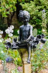 Bronze cherub water feature in a formal garden