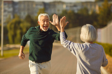 Good job. Well done. Two happy old people finish jogging and have fun. Cheerful excited male...