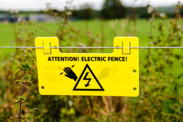 Warning sign on an electric fence around a field