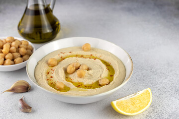 Classic chickpea hummus with, olive oil, parsley and lemon on a gray background. Arabic, Turkish cuisine.