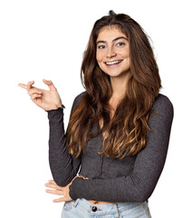 Young Caucasian woman in studio setting smiling cheerfully pointing with forefinger away.