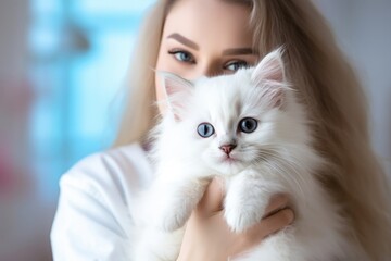 Young vet doctor girl holding cute little white kitten with love and care at veterinarian for exam.