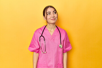 Nursing assistant in yellow background dreaming of achieving goals and purposes