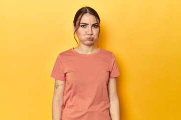 blows cheeks, has tired expression. Facial expression concept. - obrazy, fototapety, plakaty